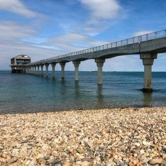A long bridge leads to Bembridge lifeboat station, with a stony beach in the foreground