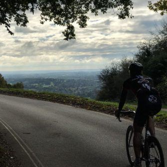Cyclist approaching view from top of Box Hill Surrey UK