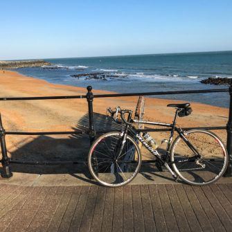 Golden sands with bicycle in front of railings at Ventnor esplanada