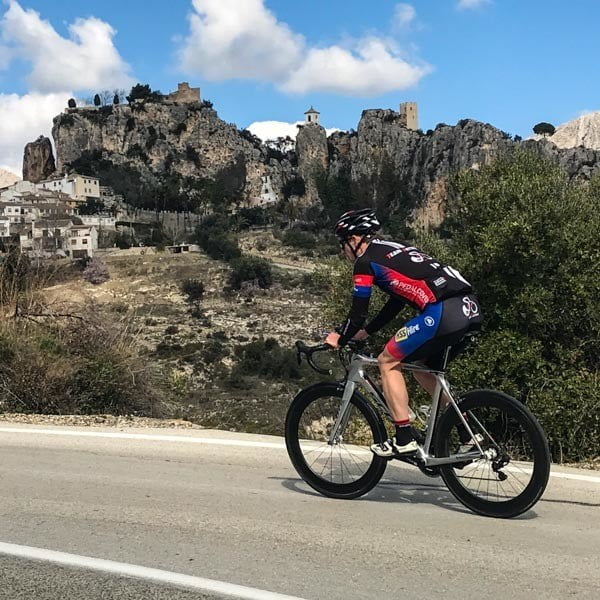 Cyclist cycling past Guadelest Costa Blanca