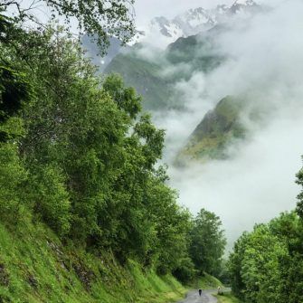Cyclist descending with mountain backdrop, French Pyrenees