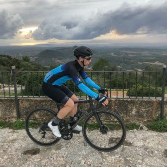 View from outside Santuari de Cura Mallorca at sunset with cyclist in foreground