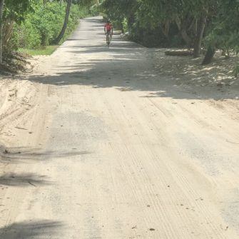 Sand on the road with cyclist approaching