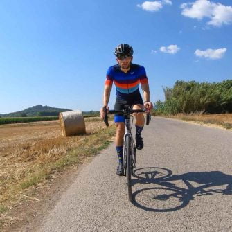 On a cycling holiday in Girona Costa Brava cycling down road with hay bales