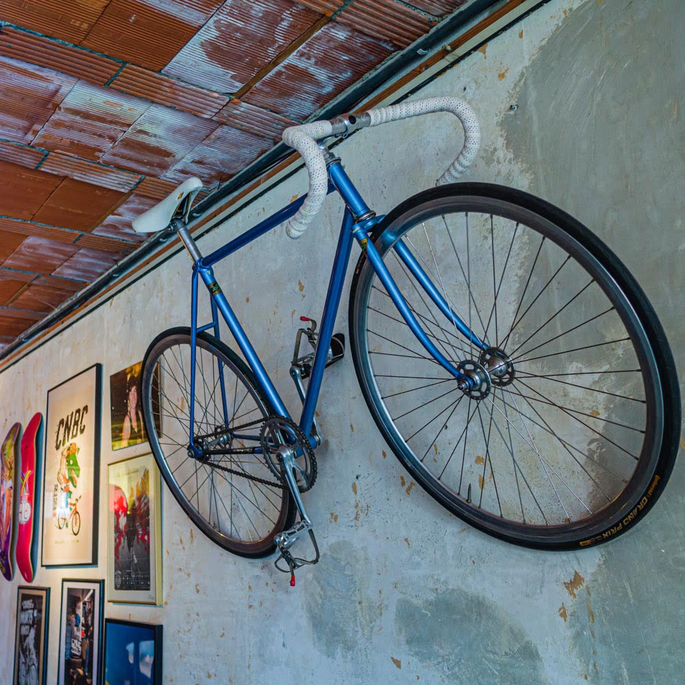 There is a bicycle hanging on the wall in biking brussels