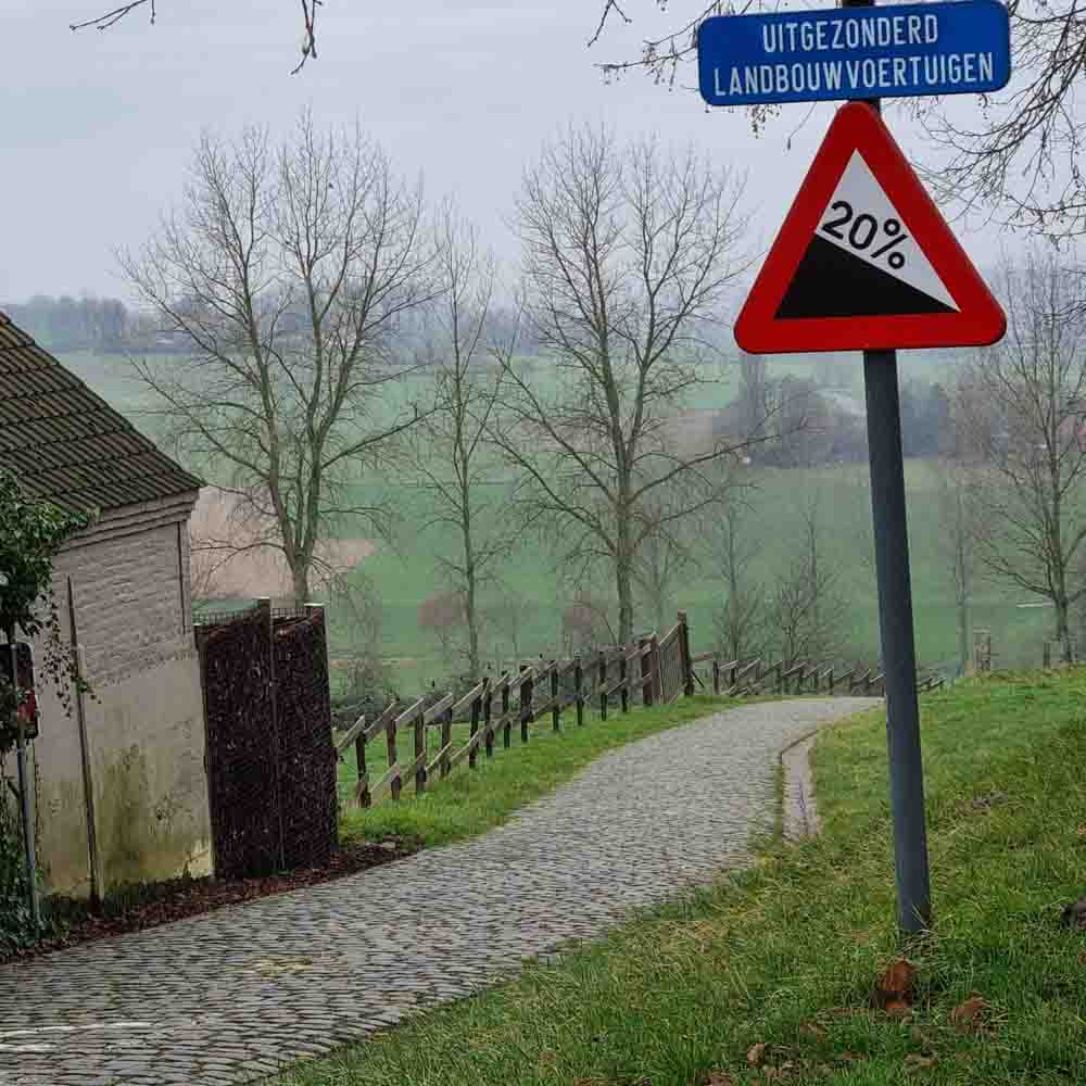 A signboard with 20% sloping road signs in bike tours belgium