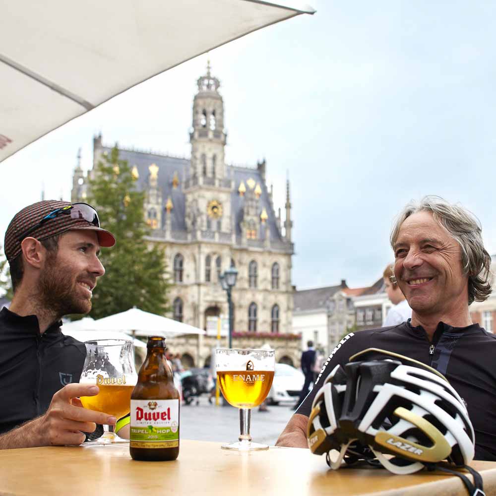 Two cyclists are resting at noon come on bike tour in belgium