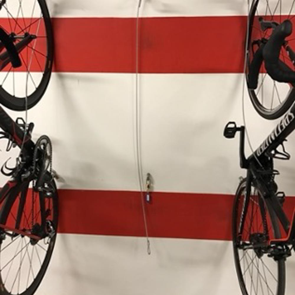 Two bikes hang on the garage wall in the cycling hotel