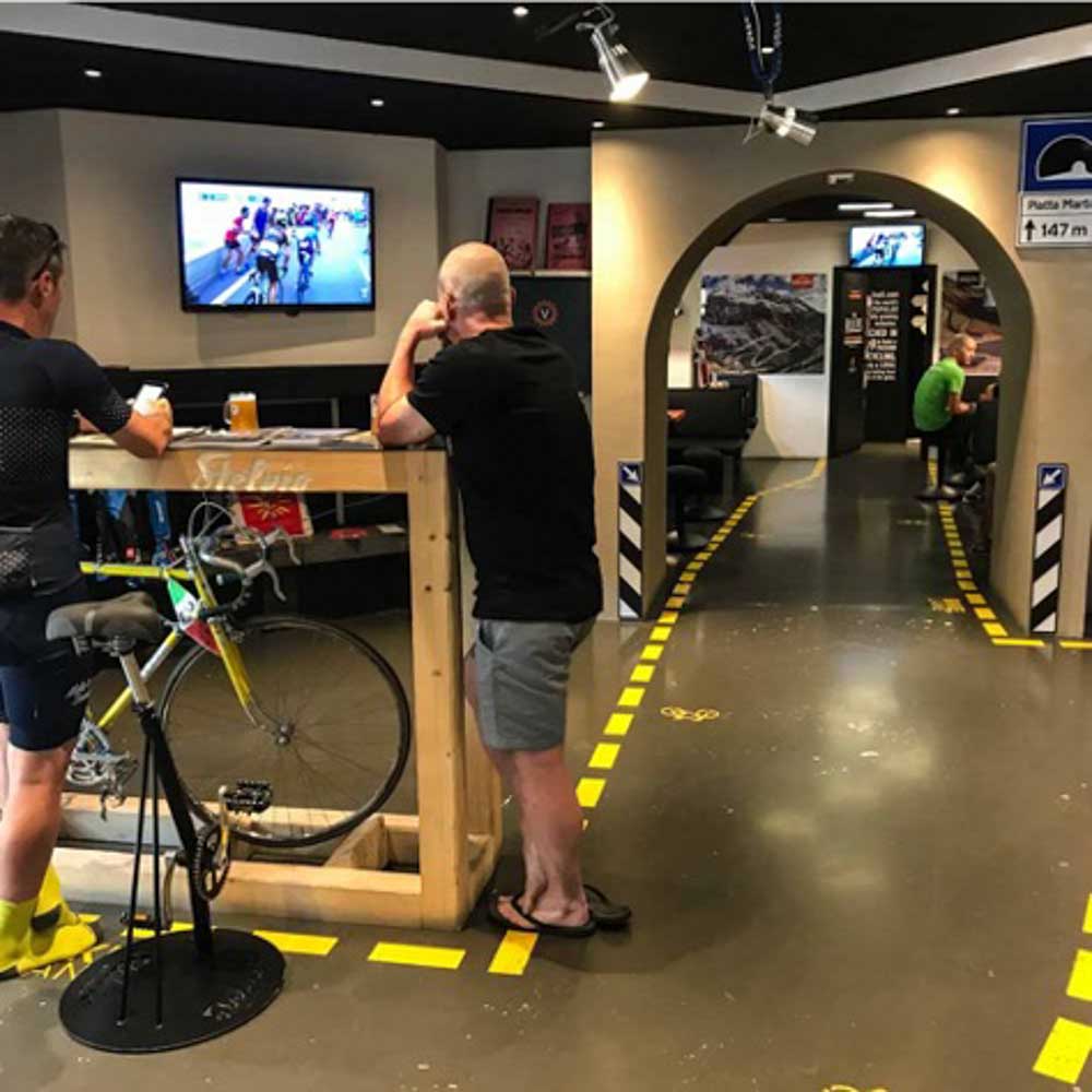 In a bike-friendly hotel two people are watching a bicycle show on tv